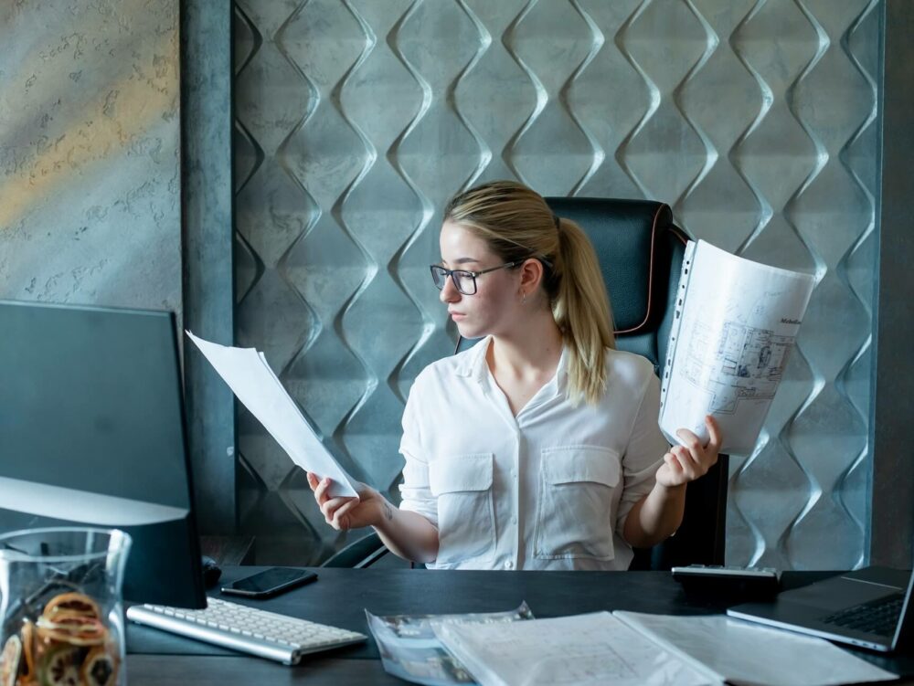 Portrait of a young office worker reviewing documents with a serious expression, indicative of the diligence required in audit readiness processes.